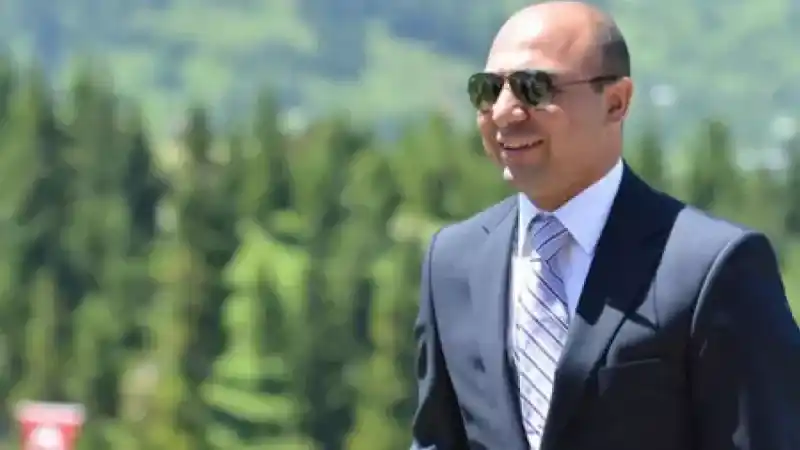 Osman Çangal, koyu renk takım elbisesiyle açık havada